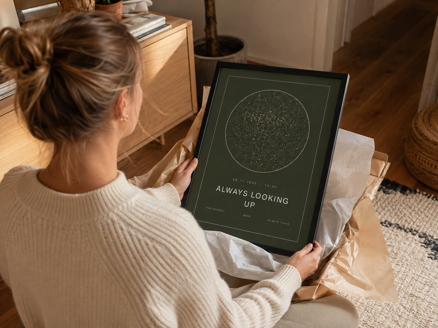 Woman unwrapping a framed green star map print